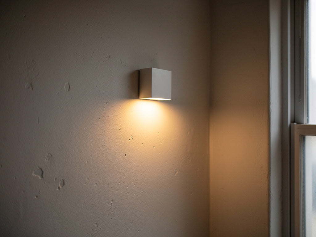 Battery operated wall lamp glowing in a dark hallway with no outlet nearby